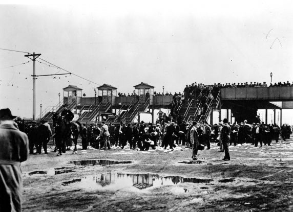 Members of the crowd that witnessed the violent confrontation between Ford Service employees and UAW organizers clean up handbills that were released during the fight from the Miller Road Overpass onto Ford Property, Ford Rouge Plant, Dearborn, Michigan.
