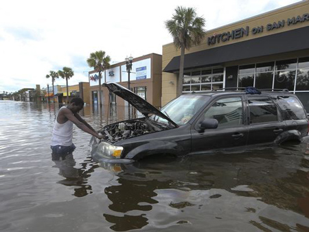 John Duke tries to figure out how to salvage his flooded vehicle in the wake Hurricane Irma this week. An estimated 200,000 to 400,000 vehicles were damaged by Irma.